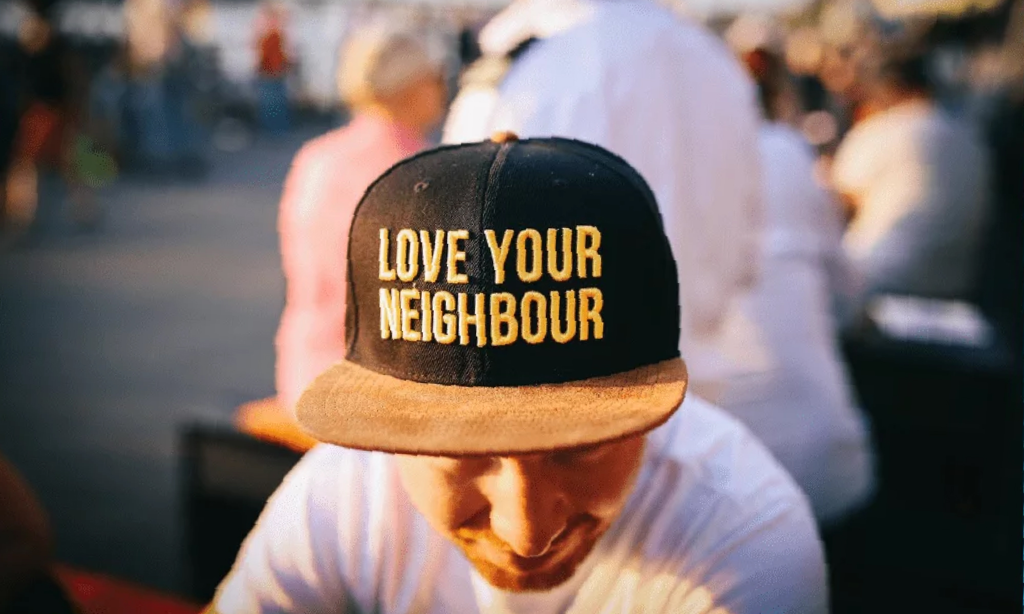 Chap wearing a cap that says Love Your Neighbour